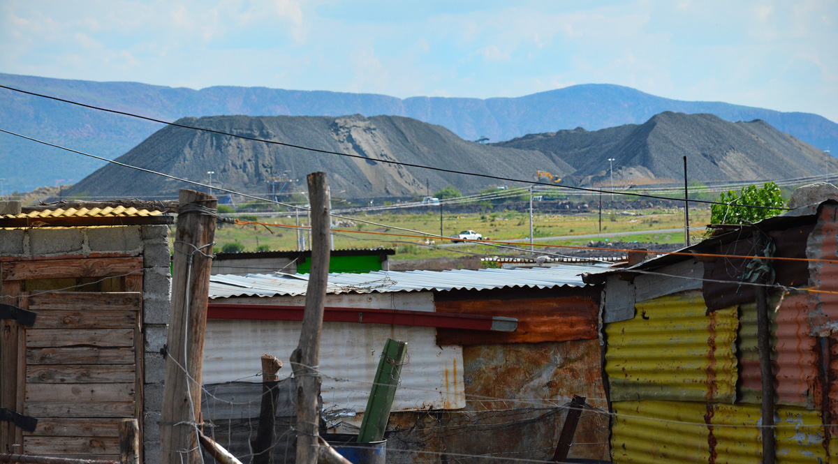 A platinum mine looms over a nearby settlement in South Africa