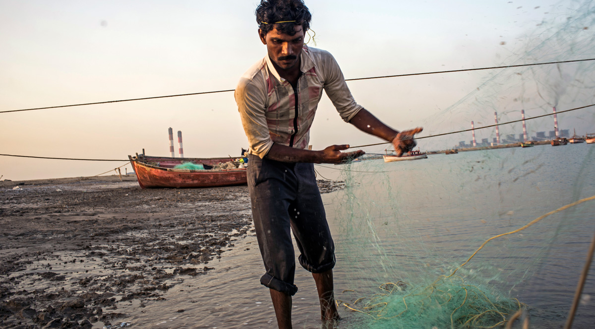 A fisherman near Mundra, India, prepares the net for the next day's fishing trip
