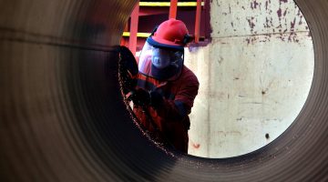 A worker inspects a Saipem gas pipe