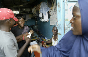 Marian Debo, second from left, from Medecins Sans Frontieres (MSF), distributes condoms at a shop in Lagos