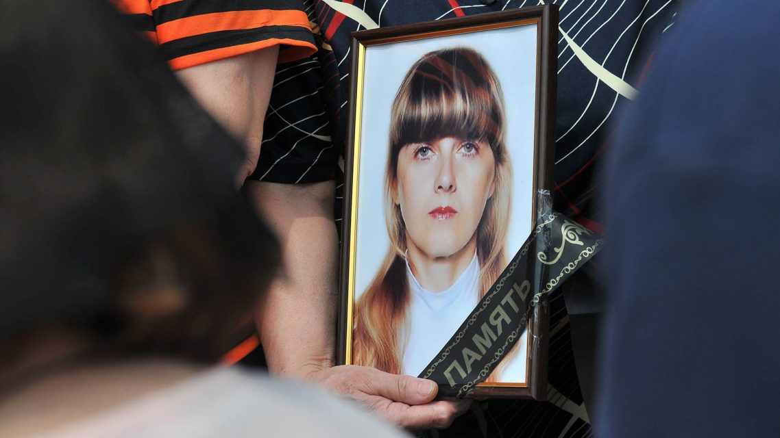 Relatives hold Nadezhda Kulinich's portrait during a funeral