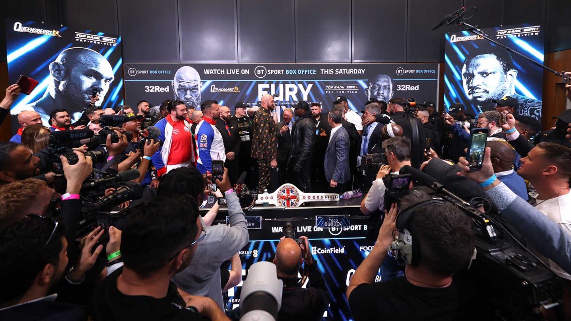 Photo showing media crowding Tyson Fury and Dillian Whyte