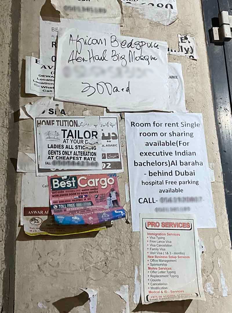 A collection of signs plastered on the wall advertising "African bed space"