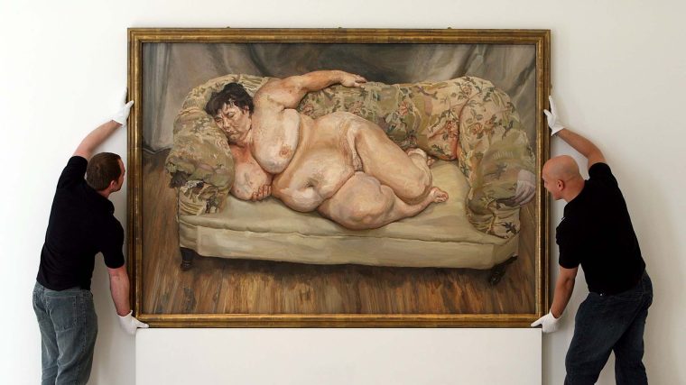 Two men hang a portrait of a sleeping naked woman — Lucian Freud's "Benefits Supervisor Sleeping"