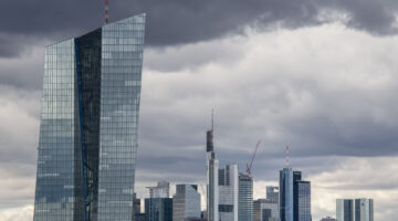 A tall, angular skyscraper against a cloudy city skyline.