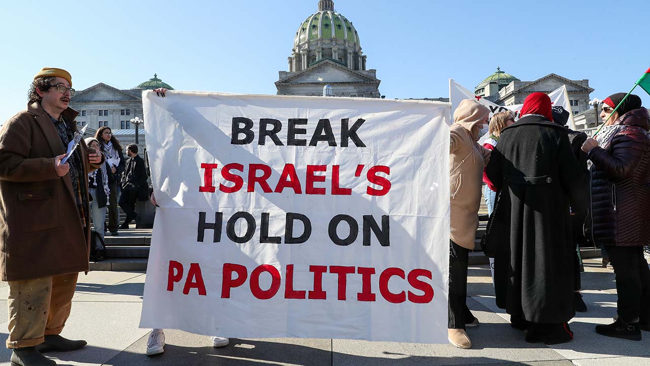 Photo of protesters holding a banner reading Break Israel's hold on PA politics