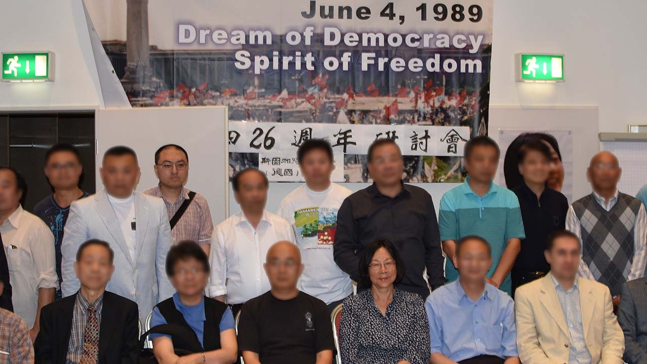 Photo of a group of people including Guo Jian in front a banner that reads June 4 1989 Dream of Democracy Spirit of Freedom.