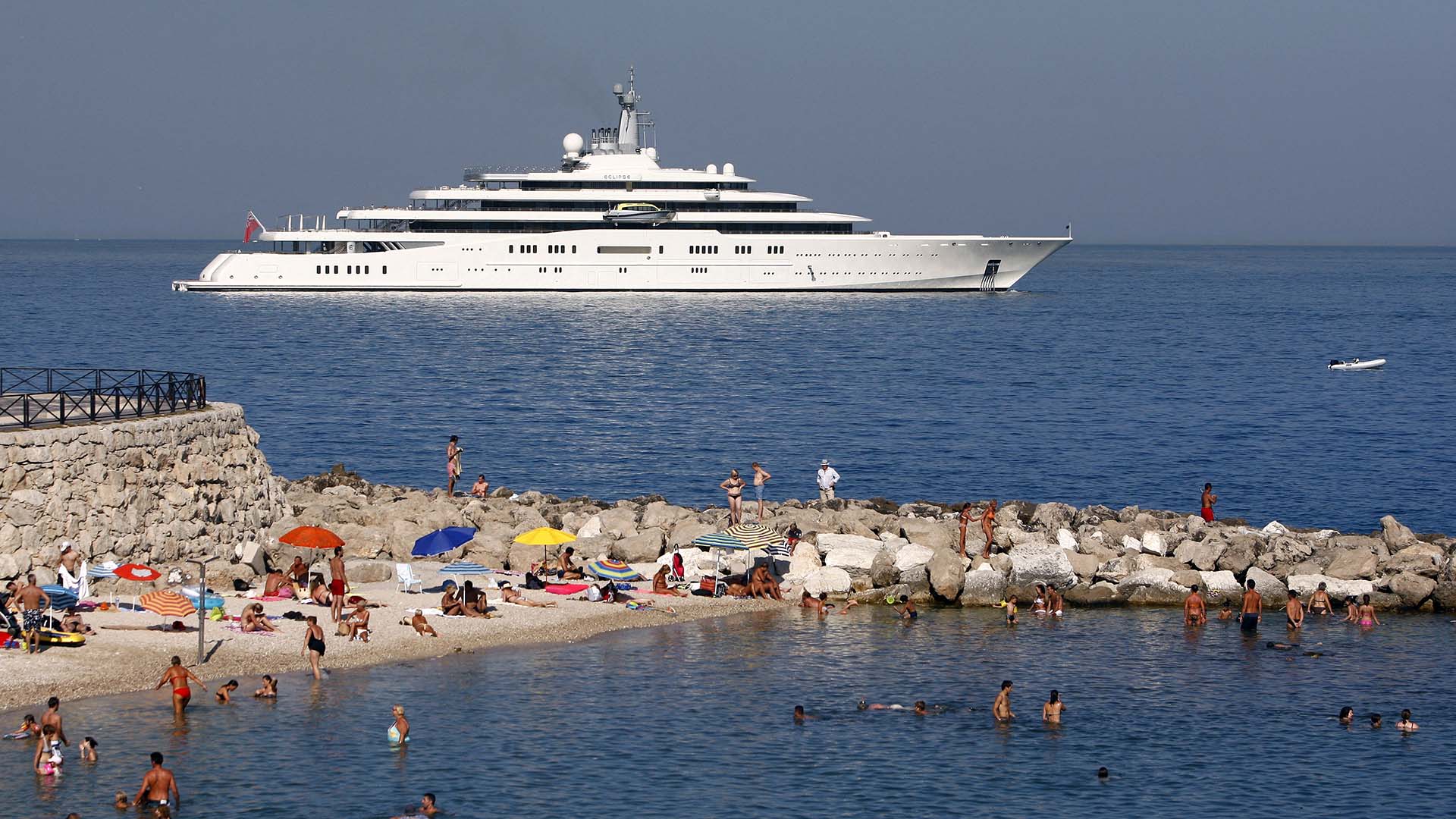 Photo of Roman Abramovich's superyacht Eclipse moored off the French coast in 2011, with beachgoers in the foreground.