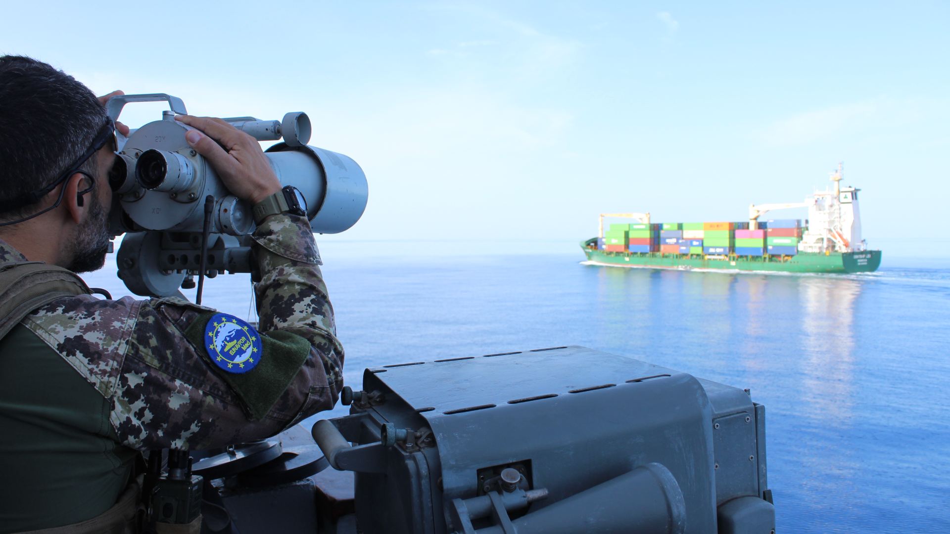 Soldier surveils a cargo ship as part of Operation Irini in the Mediterranean Sea.