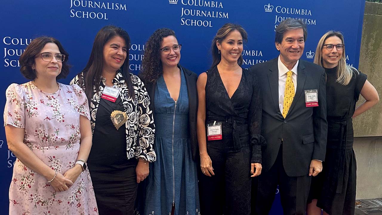 Nora Gámez Torres, Paola Margot Ugaz Cruz, Natalia Viana, Omaya Sosa Pascual, Jaime Abello Banfi and Isabella Cota standing in front of a Columbia University banner at the Cabot Prize ceremony.