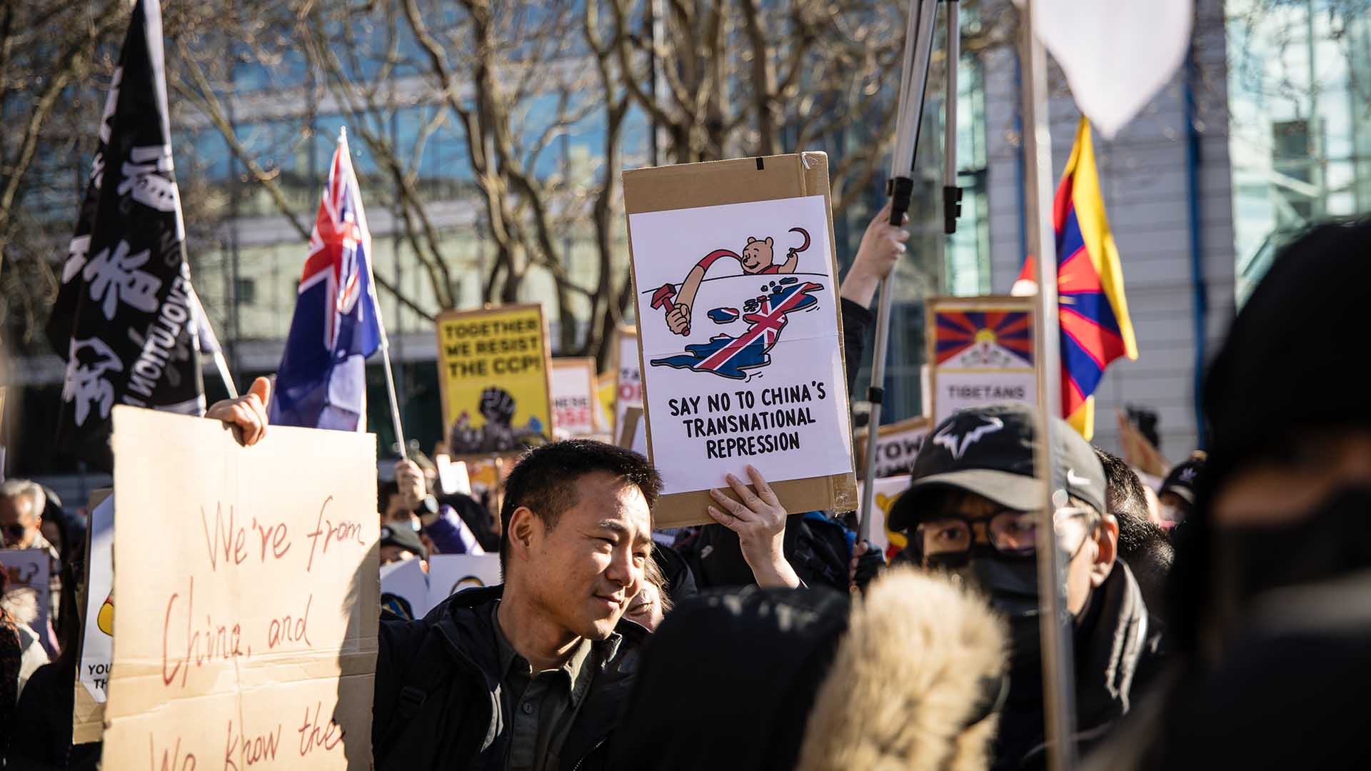 Protesters in London hold up signs opposing China's transnational repression.
