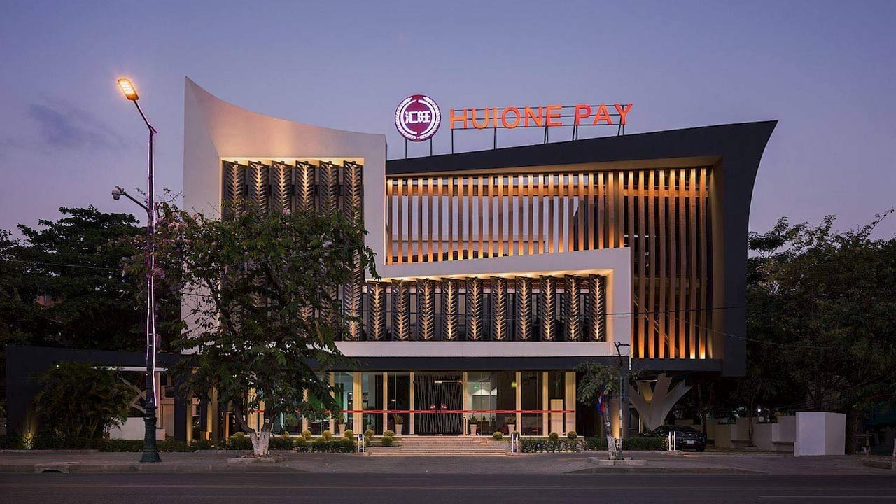 Photo of an office building with a Huione Pay sign on top.