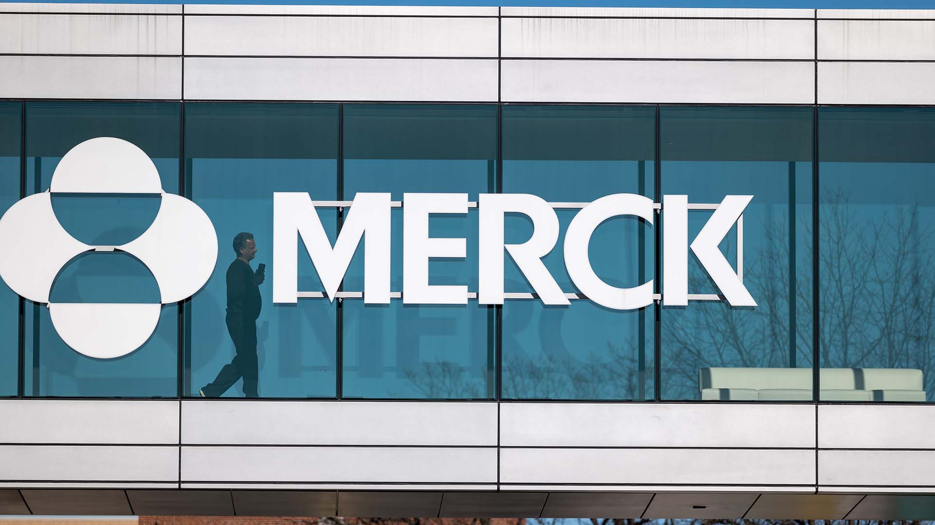 Photo of Merck logo and sign on a glass window at the company's New Jersey headquarters.