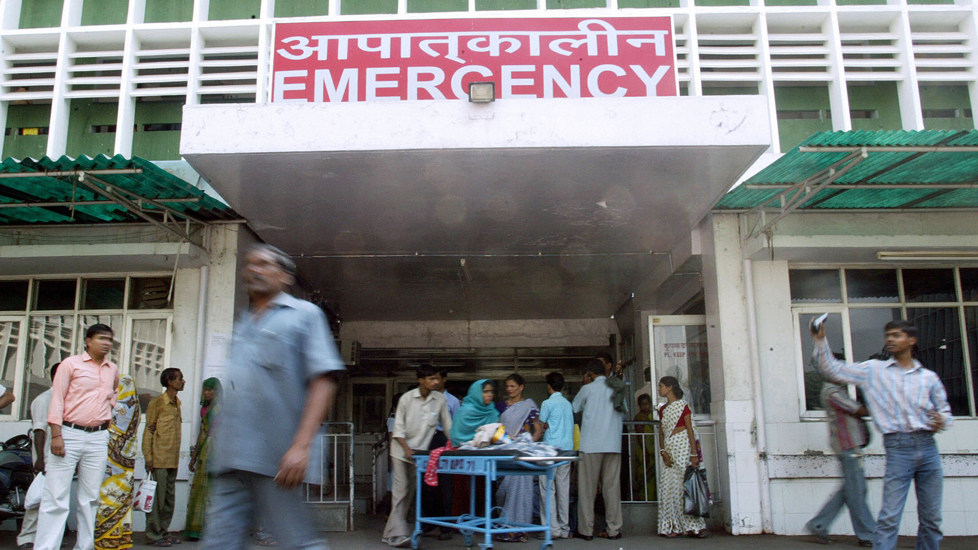 Indian patients and visitors walk out of hospital
