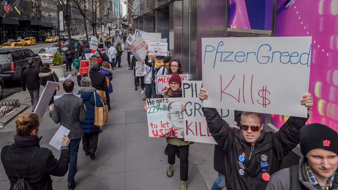 Photo of protesters outside Pfizer's New York office holding signs, including one that reads Pfizer greed kills.