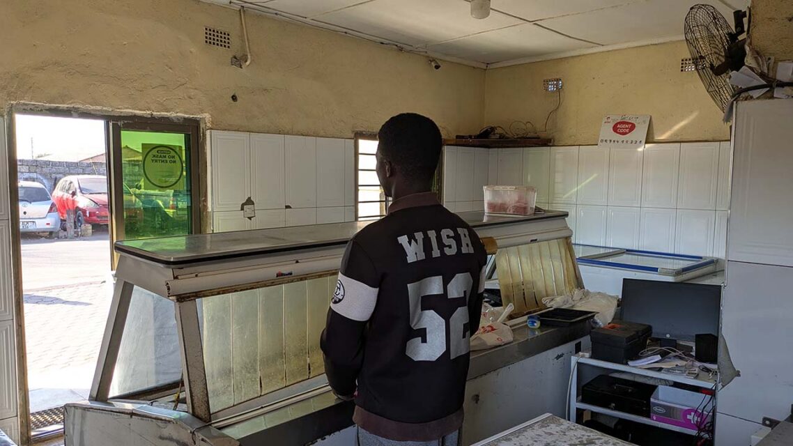 Photo of a man standing in an empty butcher's shop.