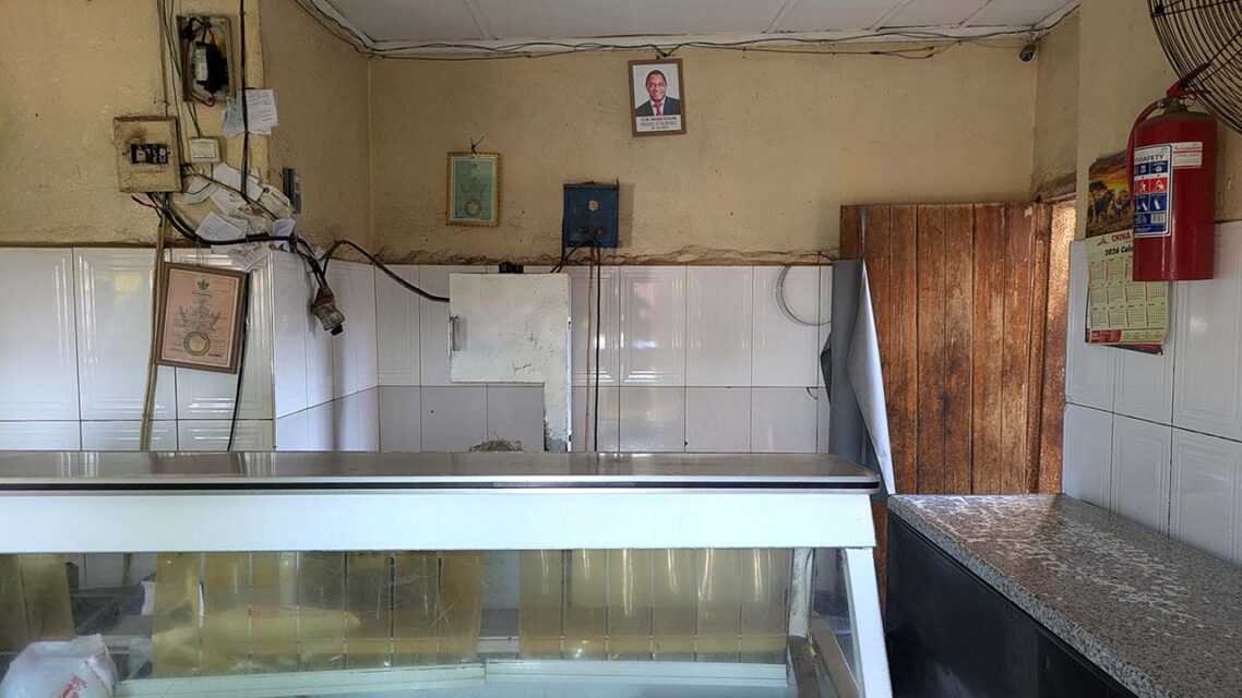 Photo of an empty butcher shop, with a picture of Zambian president Hichilema hanging on the wall.